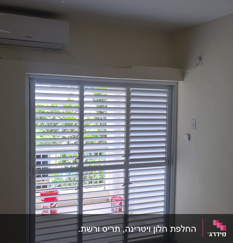 תריסי אלומיניום לבנים על חלון זכוכית